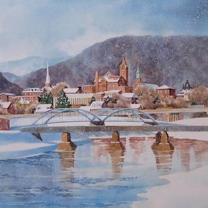 May include: Watercolor painting of a snow-covered town with a bridge over a river. Buildings with red brick and brown roofs are visible, along with church steeples. Mountains are in the background, and the sky is a light blue.