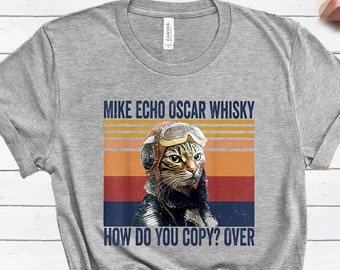May include: A gray t-shirt with a vintage-style graphic of a cat wearing aviator goggles and a scarf. The text on the shirt reads "Mike Echo Oscar Whisky How Do You Copy? Over".