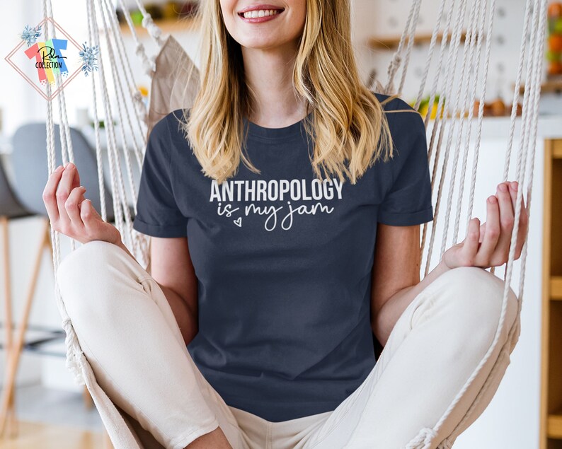 May include: A woman wearing a navy blue t-shirt with the text "ANTHROPOLOGY is my jam" in white lettering. The shirt has a small heart symbol before the word "my".