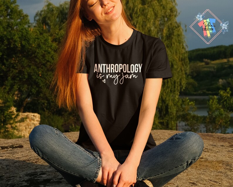 May include: A woman wearing a black t-shirt with the text "ANTHROPOLOGY is my jam" in white lettering. The shirt has a heart symbol next to the word "my".