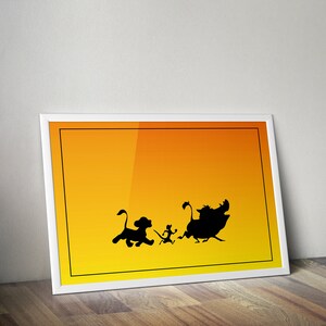 Può includere: Una stampa incorniciata bianca con uno sfondo sfumato dal giallo all'arancione. Le silhouette di Simba, Timon e Pumbaa del film Disney Il Re Leone corrono sullo sfondo.
