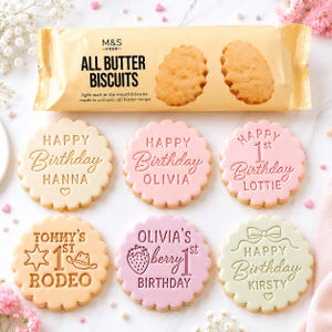 May include: A packet of M&S Food All Butter Biscuits positioned above six round, scalloped-edged biscuits with embossed text. The biscuits display various personalised birthday messages, including names such as Hanna, Olivia, Lottie, Tommy, and Kirsty, with icons.