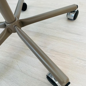 May include: A brown metal office chair base with five wheels. The wheels are made of black rubber and have a silver metal rim.