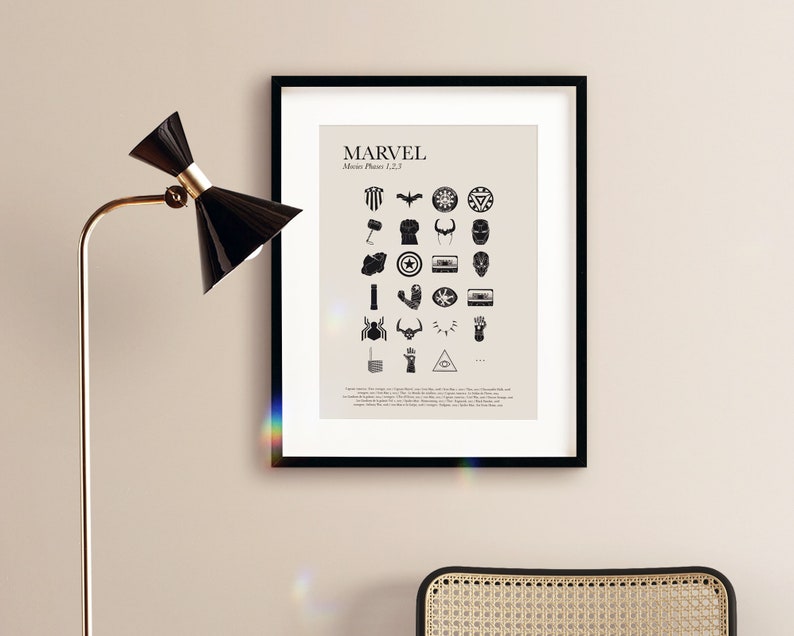 May include: A black framed print with the word "MARVEL" and the text "Movie Phases 1, 2, 3" in white. The print features a grid of black and white icons representing characters and objects from the Marvel Cinematic Universe.