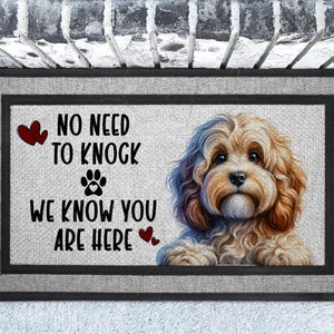 May include: A doormat with a brown and white dog with a paw print and the text "No need to knock we know you are here" with red hearts.