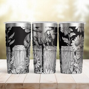 May include: Three stainless steel insulated tumblers with black and white bee and floral designs. Each tumbler features a detailed illustration of a bee, flowers, and a wooden fence. The tumblers have a silver lid and are set on a wooden surface.