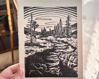 May include: Black and white landscape print titled "Lake Fork" featuring a river scene with trees and mountains. The print has a textured, deckled edge and is signed and dated 12/24/25.