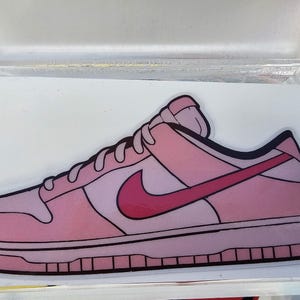 May include: A pink and red sneaker with a white swoosh logo. The sneaker is a cartoon illustration.