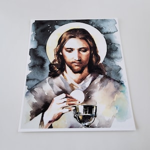 Puede incluir: Una pintura de acuarela de Jesucristo sosteniendo una copa y una hostia. La pintura est&aacute; sobre un fondo oscuro con un halo de luz alrededor de la cabeza de Jes&uacute;s.