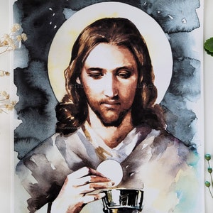 Puede incluir: Una pintura de acuarela de Jesucristo sosteniendo una hostia y un c&aacute;liz. La pintura est&aacute; hecha en tonos de marr&oacute;n, blanco y azul, con un halo de luz alrededor de la cabeza de Jes&uacute;s.