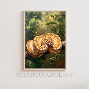 Op de afbeelding: Olieverfschilderij van een koningspython opgerold op een tak, tegen een achtergrond van weelderig groen gebladerte. Het patroon van de slang heeft tinten bruin en geel. Het kunstwerk is ingelijst en klaar om op te hangen.