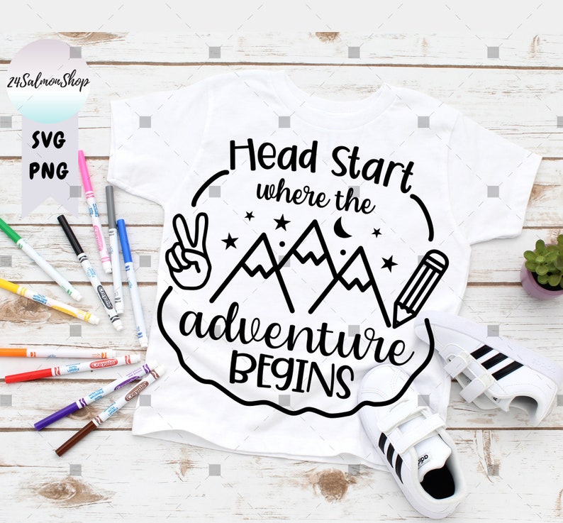 May include: White t-shirt with a black and white graphic design of mountains, a pencil, a peace sign, and the text "Head Start where the adventure begins".