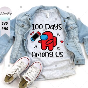 May include: A gray t-shirt with the text "100 Days Among Us" and a red Among Us character holding a video game controller. The character has a blue visor.