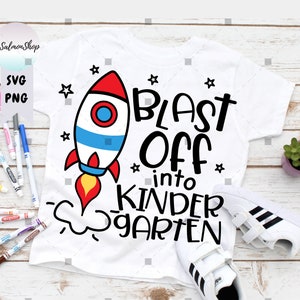 May include: White t-shirt with a red, white, and blue rocket ship graphic and the text "Blast Off into Kindergarten".