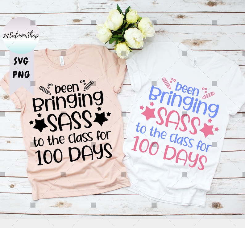 Może przedstawiać: Dwie koszulki z nadrukiem "been bringing sass to the class for 100 days". Jedna koszulka jest r&oacute;żowa, a druga biała.