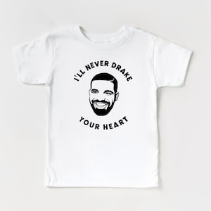 May include: White t-shirt with a black and white illustration of Drake's face and the text "I'll never Drake your heart."