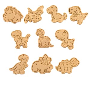 Peut inclure: Ensemble de dix emporte-pièces en plastique brun en forme de dinosaures. Les emporte-pièces sont de formes variées, notamment un tricératops, un stégosaure, un brachiosaure et un ptérodactyle.