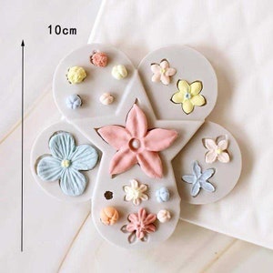 May include: A silicone mold for making fondant flowers. The mold is shaped like a flower with five petals and has a variety of different flower shapes and sizes. The mold is 10 cm in diameter.