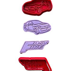 Könnte beinhalten: Drei Ausstecher, einer rot und zwei lila, in Form eines Autos und der Worte "Fast Five".