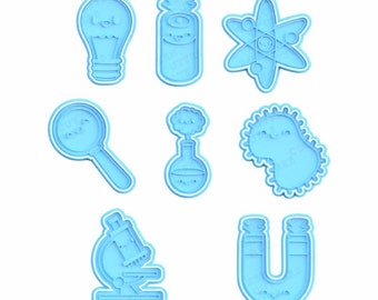 Pode incluir: Um conjunto de nove cortadores de biscoitos de plástico azul em forma de objetos com tema científico, incluindo uma lâmpada, um tubo de ensaio, um átomo, uma lupa, um béquer, uma bactéria, um microscópio e um ímã em forma de ferradura. Os cortadores estão sobre um fundo branco.