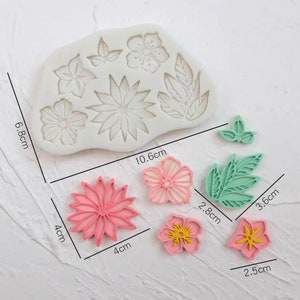 May include: Silicone mold with 7 different flower and leaf designs. The mold is 6.8 cm by 10.6 cm. There are also 5 finished fondant flowers and leaves in pink, green, and yellow.