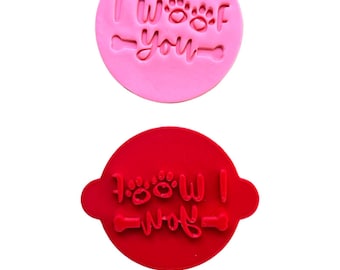 May include: Two round pink and red cookie cutters with the text "I woof you" and "Woof I" with paw prints and bone designs.