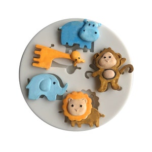 May include: A silicone mold with six different animal shapes: a blue hippopotamus, a yellow giraffe, a blue elephant, a brown monkey, a yellow lion, and a small yellow baby giraffe.