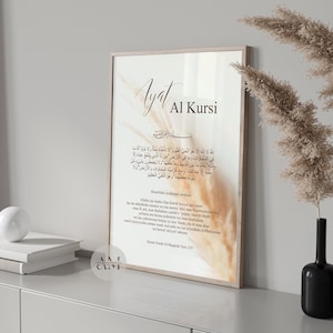 Könnte beinhalten: Ein beiger und weißer druckbarer Wandkunstdruck mit dem arabischen Text "Ayat Al Kursi" und einer englischen Übersetzung. Der Druck hat einen hellbraunen und beigefarbenen Hintergrund mit einem dezenten floralen Design.