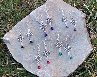 May include: A set of eight silver earrings with a Celtic knot design and dangling crystal beads. The beads are in shades of blue, green, and red.