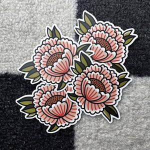 May include: Four pink and white floral stickers with green leaves. The stickers are arranged in a cluster, with the largest sticker in the center.