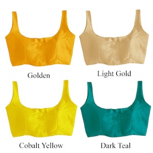 May include: Four different colored satin fabric crop tops. The colors are golden, light gold, cobalt yellow, and dark teal.