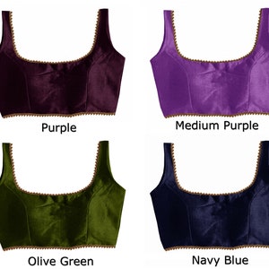 May include: Four different colored sleeveless blouses with a gold trim. The colors are purple, medium purple, olive green, and navy blue.