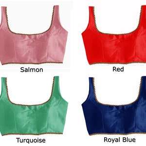 May include: Four different colored, sleeveless, satin blouses with a gold beaded trim. The colors are salmon, red, turquoise, and royal blue.