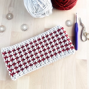 May include: A crocheted headband with a red and white checkered pattern. The headband is made with a soft yarn and is perfect for keeping your ears warm in the winter.