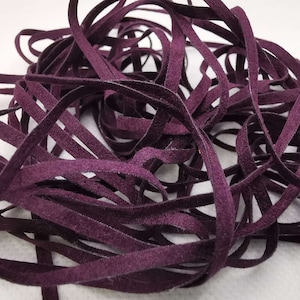May include: A pile of dark purple suede leather cord, perfect for crafting projects.