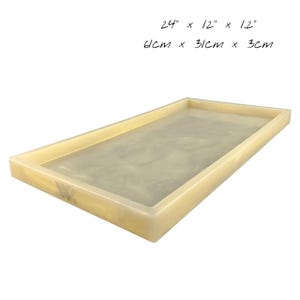 Op de afbeelding: Rechthoekige dienblad in lichtbeige met een licht gemarmerd oppervlak. De afmetingen van de dienblad zijn 61 cm lang, 31 cm breed en 3 cm diep. De afmetingen in inches staan ook op de afbeelding.