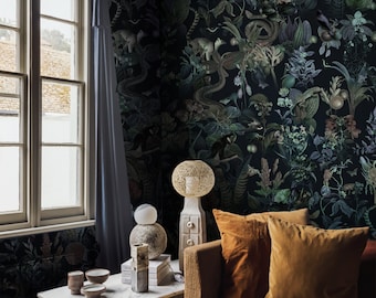 May include: A living room with a brown couch and a coffee table. The wall is covered in dark green wallpaper with a jungle print. There is a wicker ottoman in front of the couch.