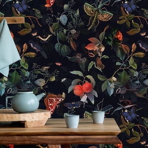 Könnte beinhalten: Eine dunkelblaue Tapete mit einem sich wiederholenden Muster aus roten Beeren, grünen Blättern, Schmetterlingen und Insekten. Die Tapete ist in einer Küchenumgebung mit einem Holztisch, einer Teekanne und zwei Tassen zu sehen.