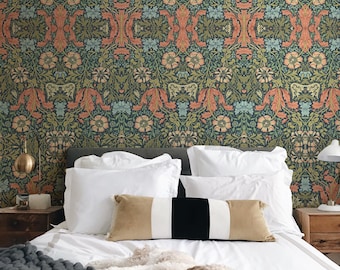 May include: A bedroom scene featuring a bed with white linens, decorative pillows, and a gray knitted blanket. A dog is resting on the bed. The wallpaper has a floral pattern in shades of green, orange, and blue.