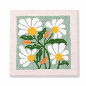 Peut inclure: Une toile de point d'aiguille verte et blanche avec un motif brodé de marguerites blanches aux centres jaunes et des accents orange. Les marguerites sont disposées en grappe avec des feuilles vertes.