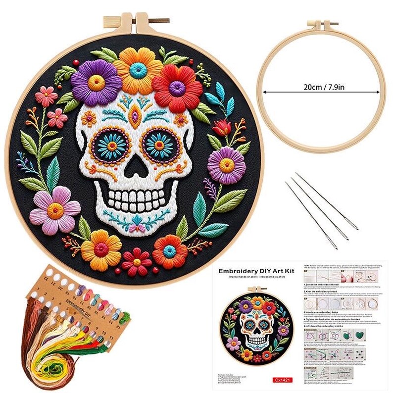 May include: Embroidery DIY art kit featuring a Day of the Dead skull design. The kit includes a black fabric hoop with a colorful floral skull, embroidery floss, needles, and a 7.9-inch (20 cm) wooden hoop.