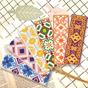 May include: Five rectangular cross-stitch bookmarks featuring distinct geometric patterns in blue, pink, yellow, green, orange, and purple threads. Each bookmark displays a unique symmetrical design, including floral motifs and intricate borders.