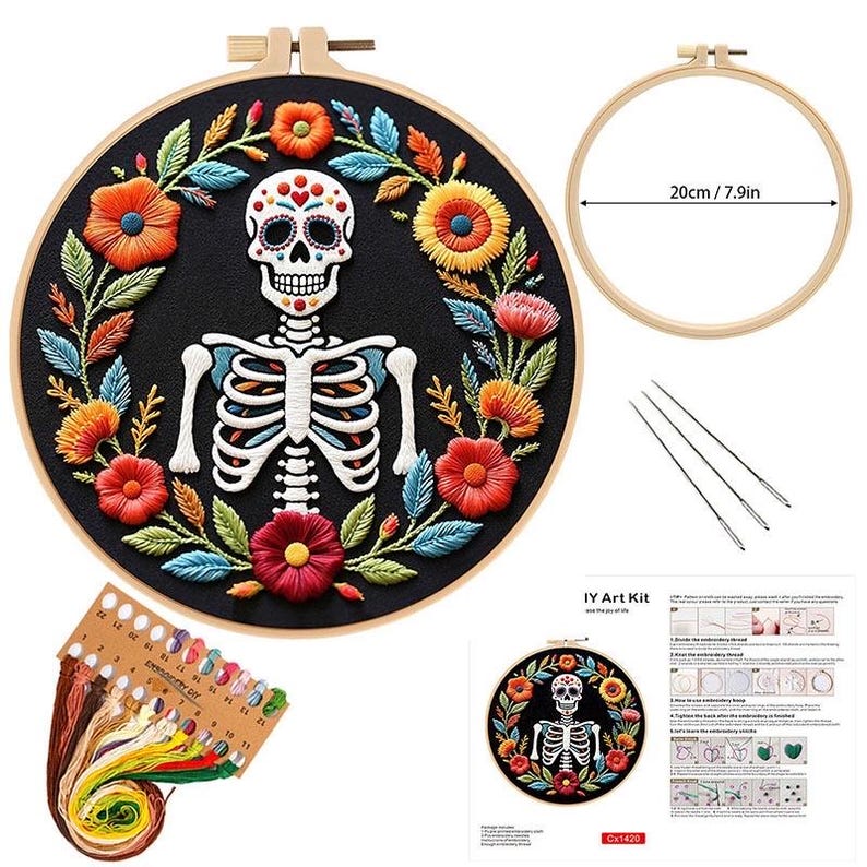 May include: Embroidery kit featuring a Day of the Dead skull design. The black fabric is surrounded by colorful floral embroidery. Includes a wooden hoop (7.9in/20cm), needles, and thread. The kit is labeled "IY Art Kit".
