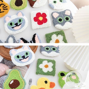 May include: A set of 11 colorful, handmade, crocheted coasters featuring various designs, including cats, flowers, avocados, a duck, and a frog. The coasters are made with soft, fluffy yarn and are perfect for adding a touch of whimsy to any home.