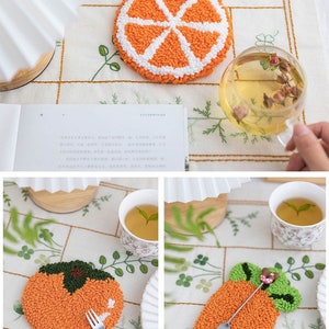 May include: Three handmade orange fruit-shaped coasters with white and green accents. The coasters are made with a punch needle technique and are perfect for adding a touch of whimsy to your home decor.