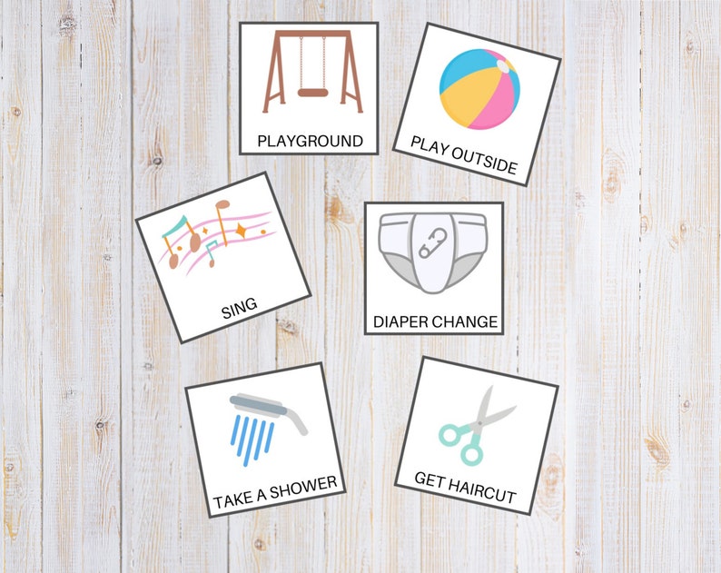 May include: Six colorful cards with illustrations and text. The cards show a swing set, a beach ball, musical notes, a diaper, a shower head, and scissors. The text on the cards reads "Playground", "Play Outside", "Sing", "Diaper Change", "Take a Shower", and "Get Haircut".