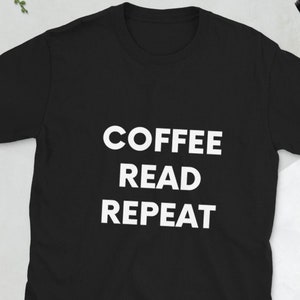 以下が含まれることがあります： 白い文字で「COFFEE READ REPEAT」と書かれた黒いTシャツです。