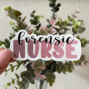 May include: A pink and white sticker with the text "forensic NURSE" in black lettering.