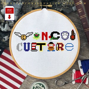May include: A white embroidery hoop with a cross-stitch design that reads "Vancouver Culture". The design includes various pop culture icons, such as a green frog, a red and white striped hat, a brown potato, and a blue paw print.