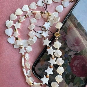 Mother of pearl phone charm chains.  Heart shaped mother of pearl beaded phone charm chains for hands free phone use.  Mobile phone accessories.
Star shaped mother of pearl phone charm chain.
Seashell mobile phone charm.
Mobile phone lanyard.